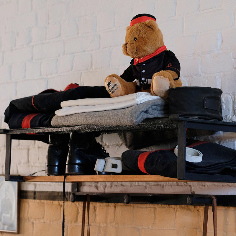 fort nelson bear in uniform with the officers kit in the barracks