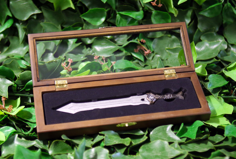 Thorin Oakenshield’s regal sword replica letter opener in open wooden display cas on a bed of ivy